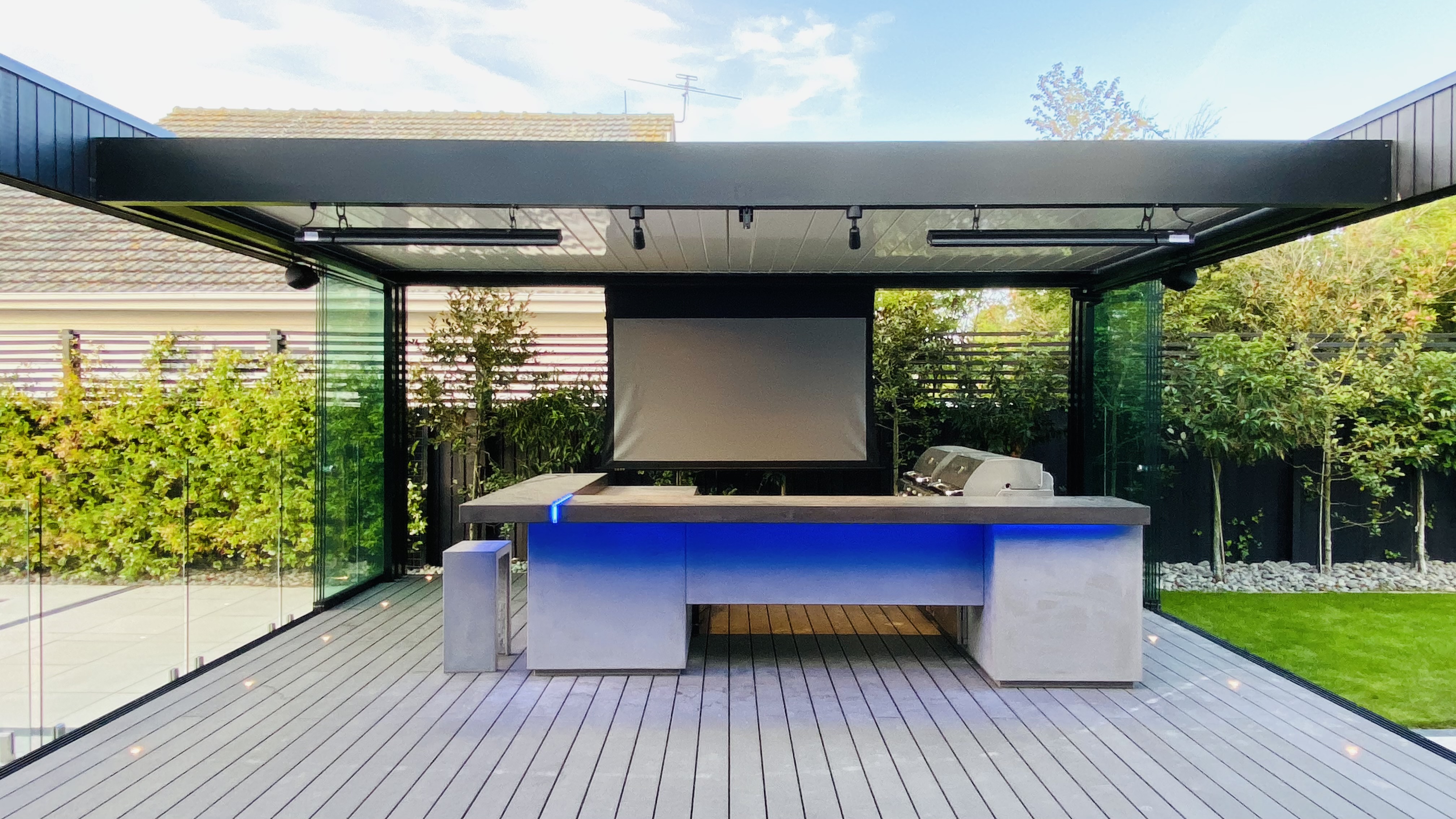 Louvred roof with sliding glazing protecting outdoor kitchen and seating