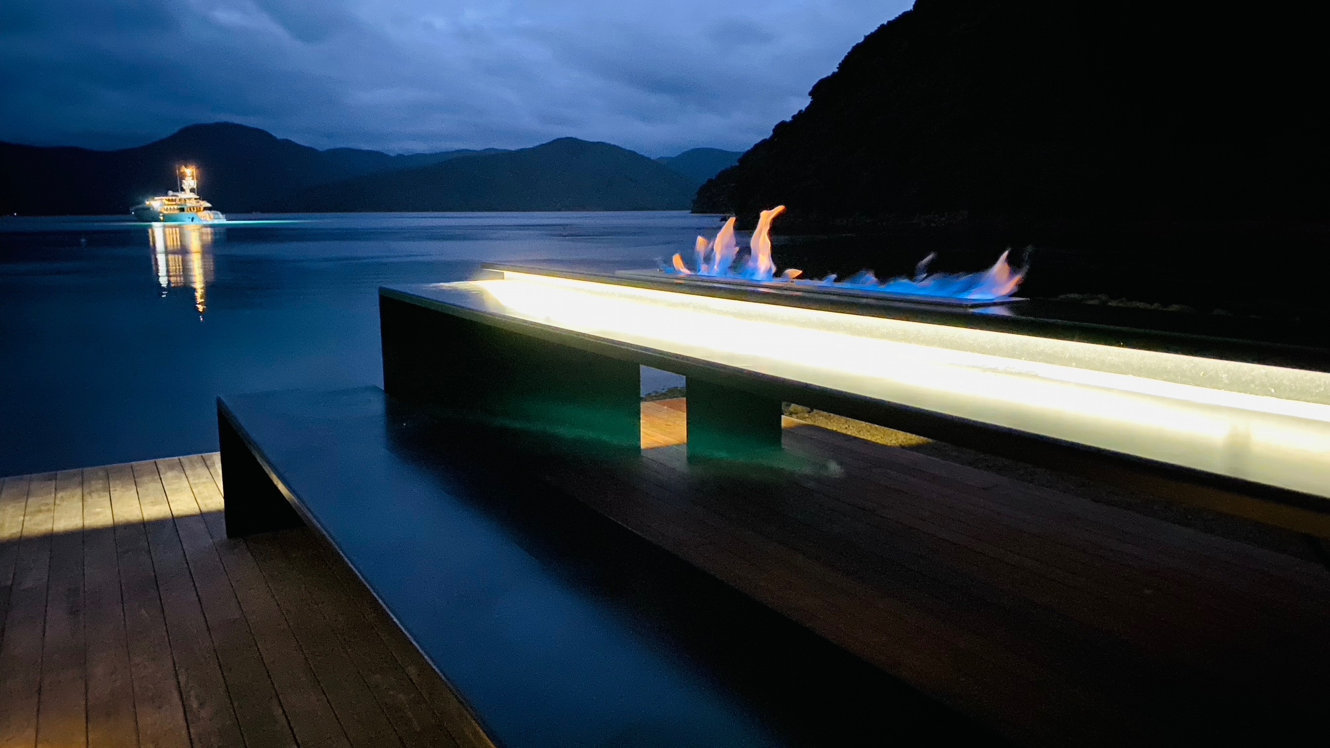 Outdoor dinner setting on the 3.5m steel table with fire feature lit